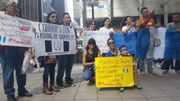 Isolda Aguilar sostiene una pancarta amarilla en la que refleja su apoyo a su país, Guatemala, azotado por fuertes escándalos de corrupción en el gobierno.