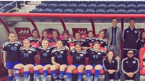 Robbie Dee, sentado a la derecha, con el equipo Varsity femenil de la escuela Curie High School.