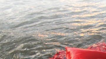 Elizabeth Lezama-Ruiz se sumerge en el Lago Michigan con su vestido rojo de Quinceañera durante su sesión fotografía después de su fiesta.