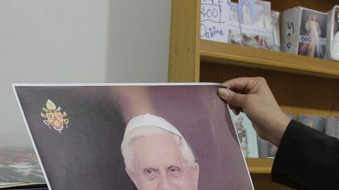 Una salvadoreña observa un afiche del Papa Benedicto XVI en la libreria de la parroquia "Jesús Manso y Humilde de Corazón" en San Salvador.