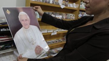 Una salvadoreña observa un afiche del Papa Benedicto XVI en la libreria de la parroquia "Jesús Manso y Humilde de Corazón" en San Salvador.