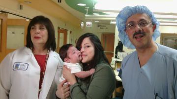 Sofía Espinoza sostiene a su segundo hijo John Carlos en brazos en medio de los doctores cirujanos Deborah Loeff (izq.) y Fuad Baroody (dcha.) el 9 de mayo 2013, en el hospital de niños de la Universidad de Chicago, Illinois.