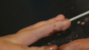 En el Centro Gads Hills, en Pilsen, Surizadny Hernández, estudiante de 15 años, usa sus dedos para crear una sonrisa en el rostro de una de las caras del fundador de la religión budista.