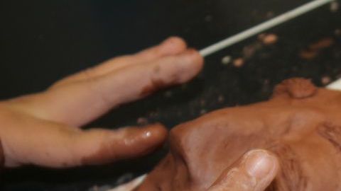 En el Centro Gads Hills, en Pilsen, Surizadny Hernández, estudiante de 15 años, usa sus dedos para crear una sonrisa en el rostro de una de las caras del fundador de la religión budista.