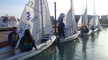 Decenas de jóvenes aprenden a navegar en el lago Michigan.