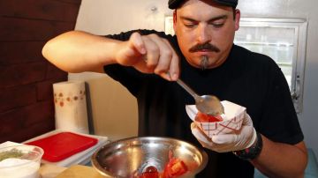 El director artístico y cocinero Efren Candelaria del Sombresa Supper Club prepara una ensalada de tomate.