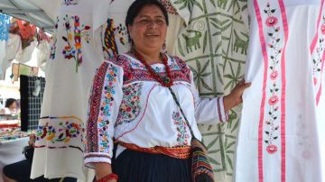 Constanza García López, una indígena mitla de Oaxaca (México), y directora de la cooperativa Vale Artesanal, junto a unos vestidos bordados por otras mujeres indígenas víctimas de violencia intrafamiliar.