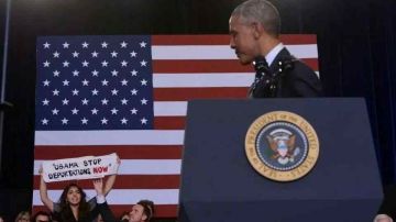 María González muestra un letrero a la audiencia en el que le pide al presidente Barack Obama que pare las deportaciones.
