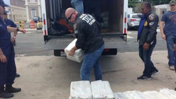 Agentes de la Agencia Antinarcóticos de EE.UU. descargan cocaína incautada.