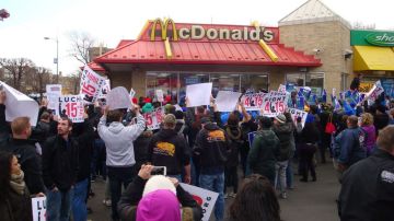 Cientos de manifestantes bloquean la entrada de un restaurante McDonalds para exigir un aumento salarial para su empleados.