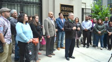 José López, cofundador del Centro Cultural Puertorriqueño junto a funcionarios electos y activistas afuera del Banco de Reserva Federal con sede en Chicago.
