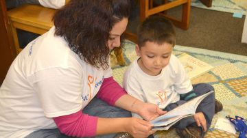 Olivia González lee un cuento a su pequeño William de 4 años, en la Biblioteca Rudy Lozano del vecindario de Pilsen.