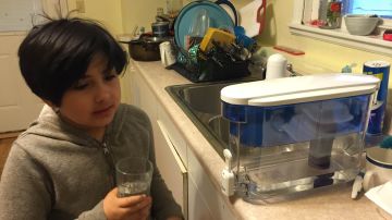 La pequeña Pilar Rodríguez, de 9 años, filtra el agua antes de consumirla en su vivienda ubicada en el suroeste de Chicago.
