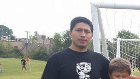 Javier Puma (izq.) exhorta al público a donar ropa usada este 25 de junio para ayudar al Chicago Cougars Soccer Club.