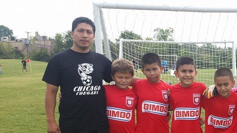Javier Puma (izq.) exhorta al público a donar ropa usada este 25 de junio para ayudar al Chicago Cougars Soccer Club.