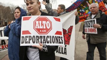 Manifestantes sostienen pancartas que piden un alto a las deportaciones.
