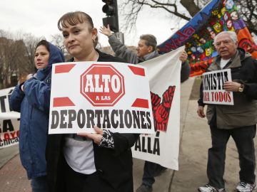 Manifestantes sostienen pancartas que piden un alto a las deportaciones.