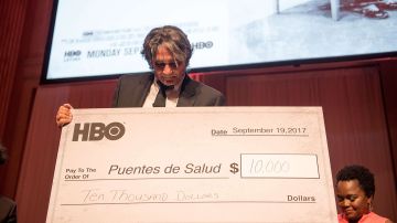 El Dr. Steve Larson, Director Ejecutivo de Puentes de Salud recibe un cheque de 10,000 dólares de HBO.  (Lisa Lake/Getty Images for HBO)