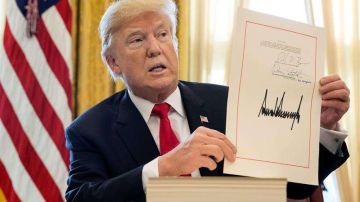 El presidente estadounidense, Donald Trump, muestra la firma de la ambiciosa reforma fiscal que incluye notables recortes de impuestos para empresas y trabajadores.