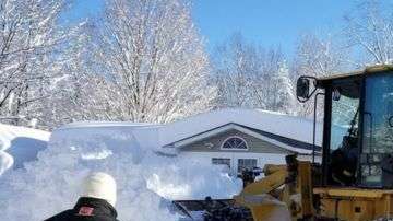 Unos bomberos tuvieron que usar una excavadora para rescatar a una mujer atrapada en su casa, en Lorraine, Nueva York.