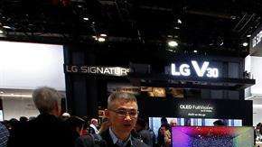 Personas observan un televisor del stand de LG durante el Salón Internacional de la Feria de Electrónica de Consumo.