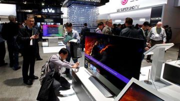 Personas observan un televisor del stand de LG durante el Salón Internacional de la Feria de Electrónica de Consumo.