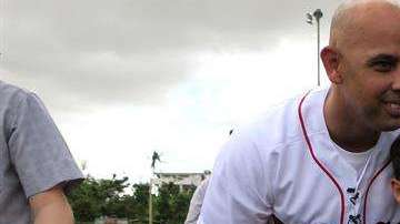 El manager de los Medias Rojas de Boston el puertorriqueño Alex Cora posa con un niño en el sector La Mesa en Caguas, cerca de San Juan, Puerto Rico. (Foto: EFE/Jorge Muñiz)