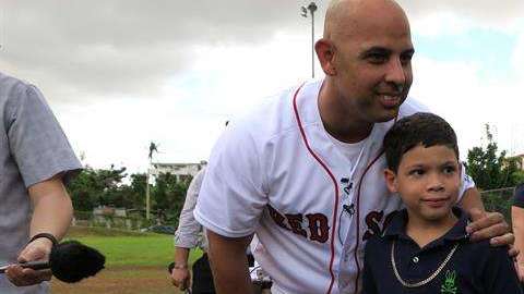 El manager de los Medias Rojas de Boston el puertorriqueño Alex Cora posa con un niño en el sector La Mesa en Caguas, cerca de San Juan, Puerto Rico. (Foto: EFE/Jorge Muñiz)