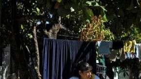 Mujer y niño junto a un grafiti del Barrio 18 en la colonia Valle del Sol en Apopa, El Salvador