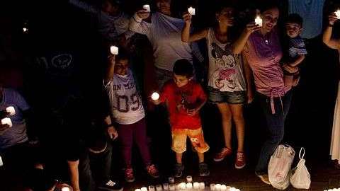 La gente enciende velas durante la Hora de la Tierra en Plaza Jardin en Cali, Colombia.LUIS ROBAYO/AFP