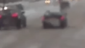 Una mujer en muletas cae al piso cruzando la carretera nevada y un conductor corre a salvarla.