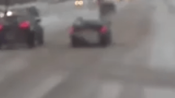Una mujer en muletas cae al piso cruzando la carretera nevada y un conductor corre a salvarla.