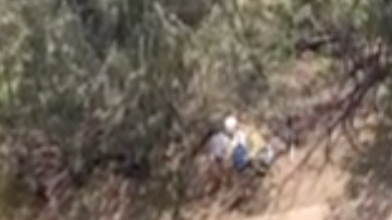 Mensaje de ayuda escrito por una pareja perdida en una isla.