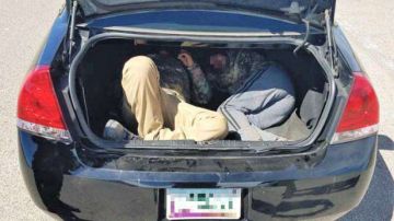 Imagen de los dos inmigrantes transportados en un maletero.