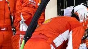 El mecánico de Ferrari Francesco Cigarini  yace en el piso tras una parada en pits de Kimmi Raikkonen durante el Grand Prix de Baréin de Fórmula 1. (Foto: EFE/EPA/GIUSEPPE CACACE / POOL)