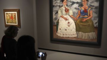 Visitantes miran la obra "Las dos Fridas" durante una exposición en Francia, en 2016.