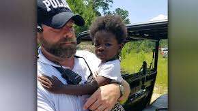 Policía rescatando a una niña en el bosque.