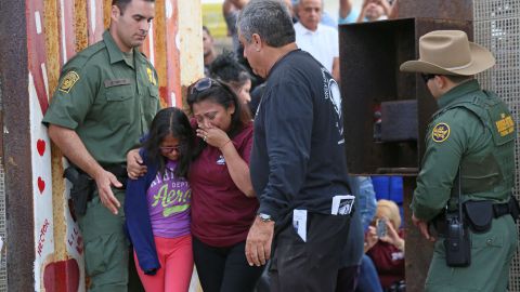 Una madre abraza a su hija en la frontera entre México y EEUU.