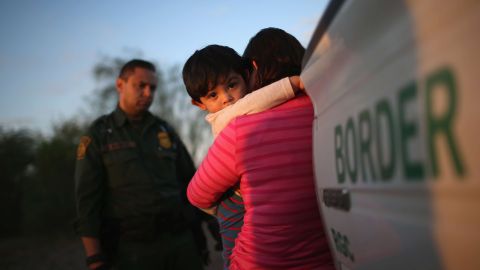 Un niño salvadoreño, de un año, abraza a su madre mientras ella se entrega a la Patrulla Fronteriza en Texas.