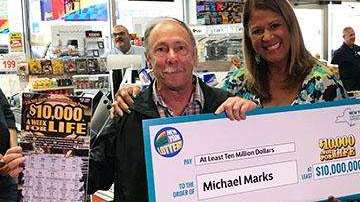 Michael Marks muestra su premio y el juego de raspadito ganador.