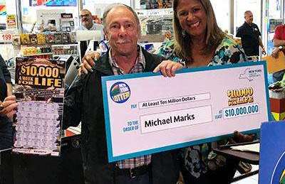 Michael Marks muestra su premio y el juego de raspadito ganador.