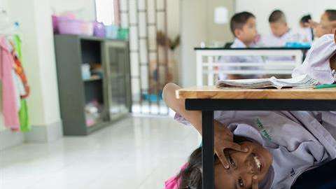 Las hermanas siamesas Pan y Pin Romphoyen juegan en una de las clases del colegio Wat Wang Phai.