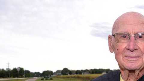 Bob Williams de Long Grove, Iowa, sentado en el banco dedicada a su difunta esposa.