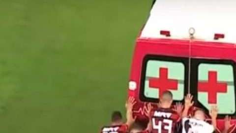 Jugadores del Flamengo y el Vasco da Gama empujan una ambulancia en la cancha.