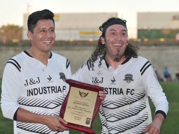 Ricardo Osorio (izquierda) recibe del también exprofesional Cosme Castro Vargas la placa de reconocimiento. (Javier Quiroz / La Raza)