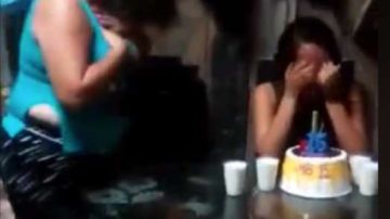 Una madre le canta a su hija en la fiesta de quinceañera.