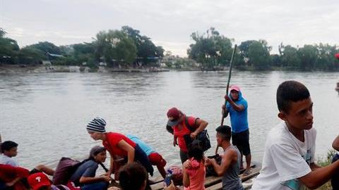 Un grupo de migrantes hondureños cruza ilegalmente el río Suchiate en balsas para llegar a México desde Tecún Umán.