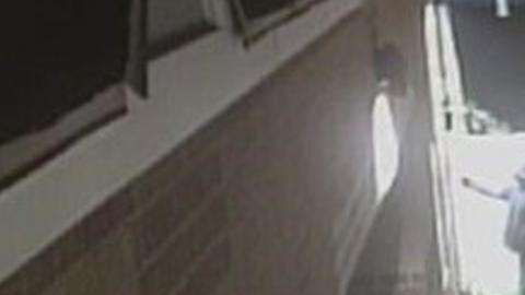 Un hombre cometiendo vandalismo nazi en una asociación judía.