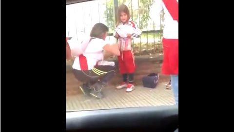 Una aficionada del River Plate coloca luces de bengala en el cuerpo de una niña