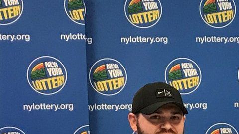 Los tres ganadores con sus cheques ceremoniales de lotería.